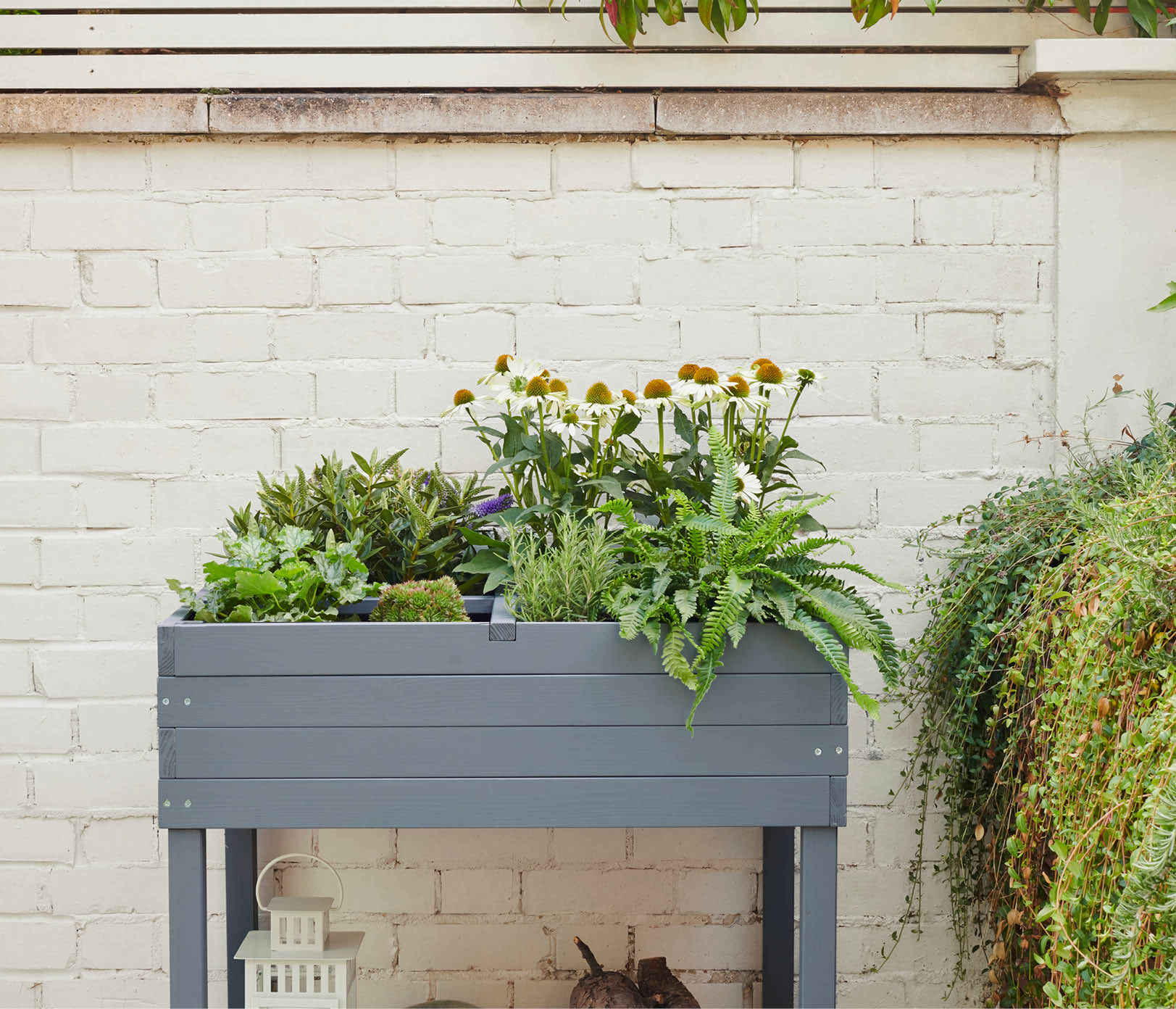 An off-white brick wall painted in Marine Grey Rust-Oleum Oyster and a grey planter 