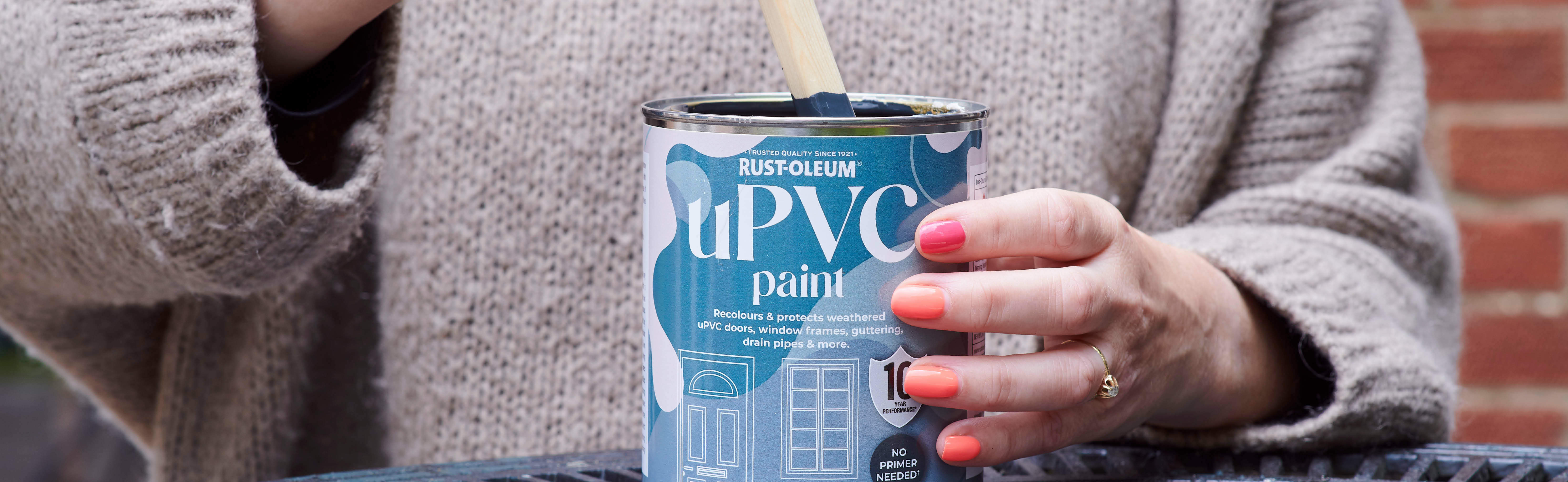 Stirring a can of uPVC paint in the colour Black Sand