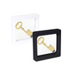 A square floating box in white and black showcasing a gold key inside. Each box has a minimalist design.