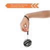 A black and grey wrist ball with a wrist strap, held by a hand, designed for leisure and outdoor activities.