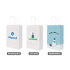 Three white kraft paper bags with twisted handles, featuring different prints and designs. One bag includes a logo, and another has a festive Christmas theme.