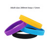 A collection of debossed silicone wristbands in purple, yellow, and black stacked together, featuring various logos.