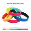Four silicon wristbands in vibrant colours: pink, blue, green, and black, featuring a logo. Kids' size displayed.