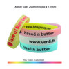 A set of silicone wristbands in pink, white, and blue with branding and customisable options.