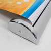 A silver pull-up banner stand with a colourful printed graphic partially rolled up.