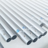 A collection of silver metal poles arranged side by side, featuring small markings on some sections.
