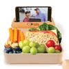 A beige eco-friendly lunch box with a phone holder, filled with fruits, vegetables, and a sandwich, featuring a logo.