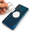 A drink bottle opener in silver being held above a blue smartphone with a white phone stand attached.