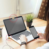 A bamboo webcam privacy pack with a laptop and smartphone on a wooden desk, featuring a plant and documents.