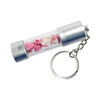 A silver storage LED USB drive in a transparent casing, featuring decorative pink and white shapes, attached to a keychain.