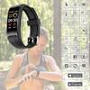A black smart band with a touchscreen display features fitness tracking functions and a logo, set in an outdoor environment.
