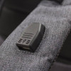 A grey backpack strap featuring a USB port. The fabric has a textured appearance.