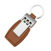 A brown leather key ring with a metallic silver attachment, featuring a logo on the silver section.
