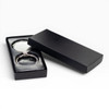 A silver keychain displayed in a black gift box, featuring a sleek design and a glossy finish.