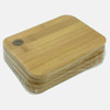 A bamboo cutting board in a stack, featuring a rounded edge and a hole for hanging. Wrapped in plastic.