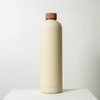 A drink bottle in a cream colour with a brown lid, featuring a minimalist design and a small logo.