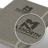 A grey Meridian Notebook with a branded logo, featuring a textured cover and elastic band closure.