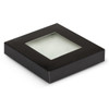 A square black box with a transparent window, containing a glass coaster set.