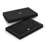 A black notebook and pen gift set displayed in an elegant black box featuring a logo.