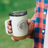 A drink bottle in light green with a cork base and a clear lid, featuring a logo on the front.