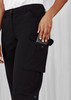 A pair of black women's cargo pants featuring side pockets and a logo, with a hand reaching for a phone.