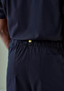 Navy unisex scrub pants with an elastic waistband and a back pocket, featuring a branding tag.
