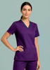 A purple women's scrub top with a V-neck design and contrasting trim, featuring two pockets.