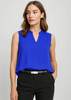 A sleeveless, cobalt blue layered blouse with a v-neck design, paired with tailored black trousers.