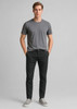A model wearing black tapered stretch chino pants paired with a grey t-shirt and grey sneakers.