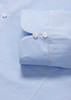 A light blue women's luxe long sleeve button-up shirt featuring a double cuff design and buttons.