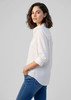 A white women's long sleeve button-up shirt, featuring a relaxed fit and rolled sleeves. It has a subtle logo.