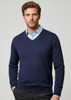 A navy men's pullover sweater with a V-neck design, worn over a light blue collared shirt. Features a logo.