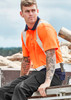 Hi-vis spliced short sleeve polo in bright orange with shoulder taping, featuring a model with tattoos seated outdoors.