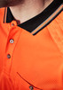 A close-up of an orange short sleeve polo shirt with a black collar and a logo. Features a pocket and buttons.