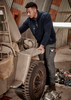 Men's Streetworx Heritage Pant in dark grey, worn by a man working on a vehicle in a garage setting.