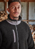 A man models a black full zip Sherpa fleece work jumper with grey detailing and a logo on the chest.