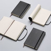 A collection of large Moleskine Classic soft cover notebooks in black, featuring lined pages and ribbon bookmarks.