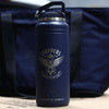 A drink bottle in navy blue with a logo and a handle, designed for hydration. Features a sleek, durable design.