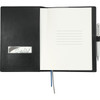 A black refillable leather journal with blank pages, a pocket for cards, and a pen attached.