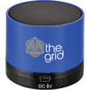 A blue cylinder Bluetooth speaker with a mesh top and a logo on the side. The base features a charging port.