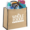 A large jute tote in brown with black handles, filled with a drink bottle, magazines, sunglasses, and a beach towel.