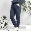 Unisex navy sweatpants with side pockets and elastic cuffs, featuring a drawstring waist. Includes a logo.