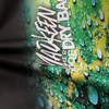 A close-up of a full colour dry bag featuring a vibrant green and yellow design with water droplets. The bag has a logo.