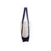 A small canvas tote bag featuring a cream body and navy blue straps and base, with a logo on one side.
