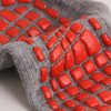 A pair of grey socks featuring vibrant red gripper patterns integrated into the fabric.