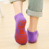 Low cut kids' gripper socks in purple with red non-slip grips on the soles, displayed from a rear angle.