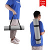 A yoga mat is carried by an individual, featuring a grey design and black straps for easy transport.
