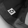 A black cap with a recyclable materials label inside, featuring a logo and breathable fabric.