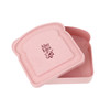 A pink portable bamboo fibre lunch box shaped like a slice of bread, with an embossed logo inside.