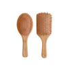Two bamboo hair brushes with padded bases and wooden bristles, showcasing a natural, earthy aesthetic.